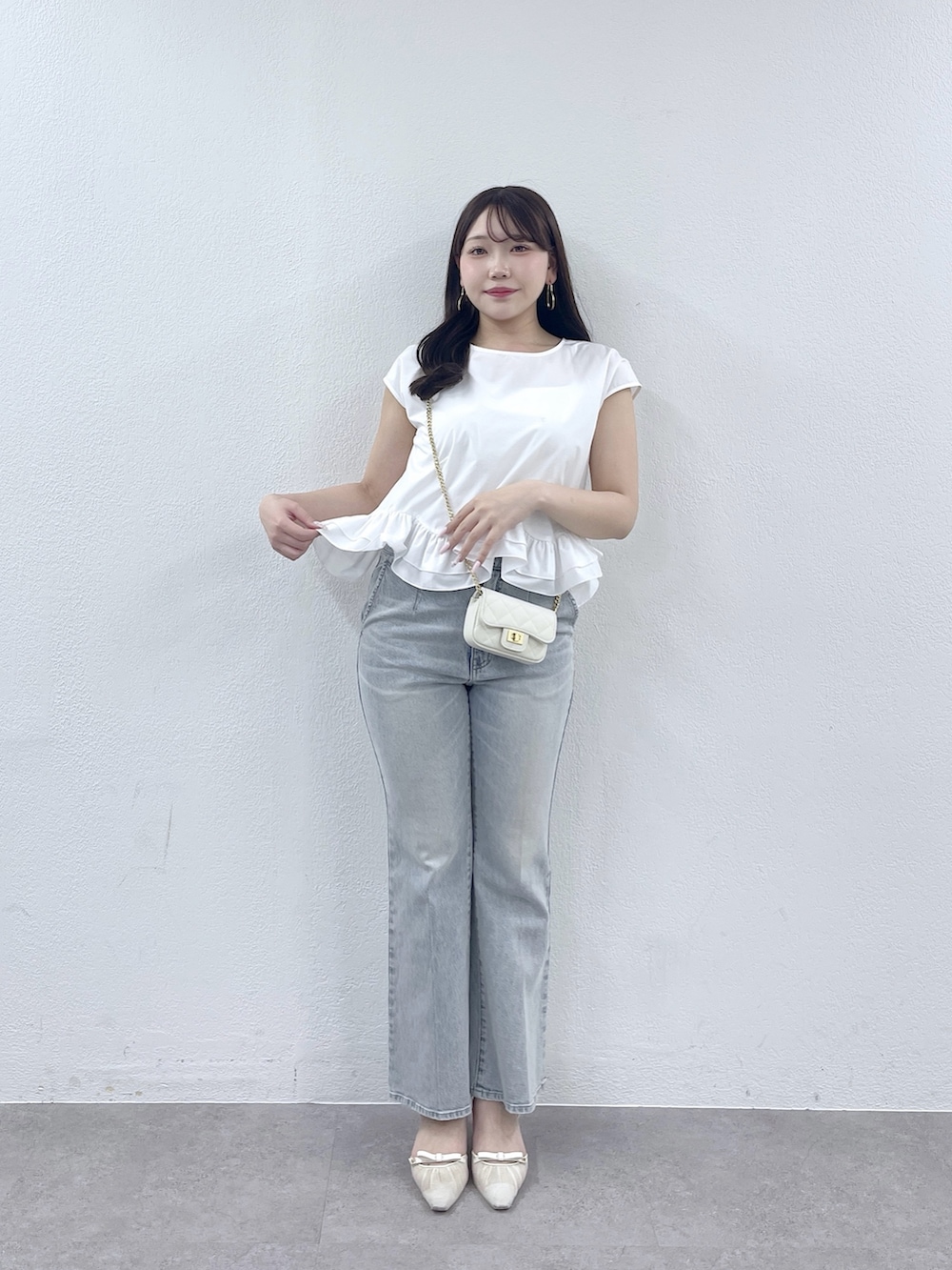 ホワイト系のシャツ/ブラウス、ホワイト系のトートバッグ、ブルー系のデニムパンツを着用したレディースの春コーディネートの2枚目の写真