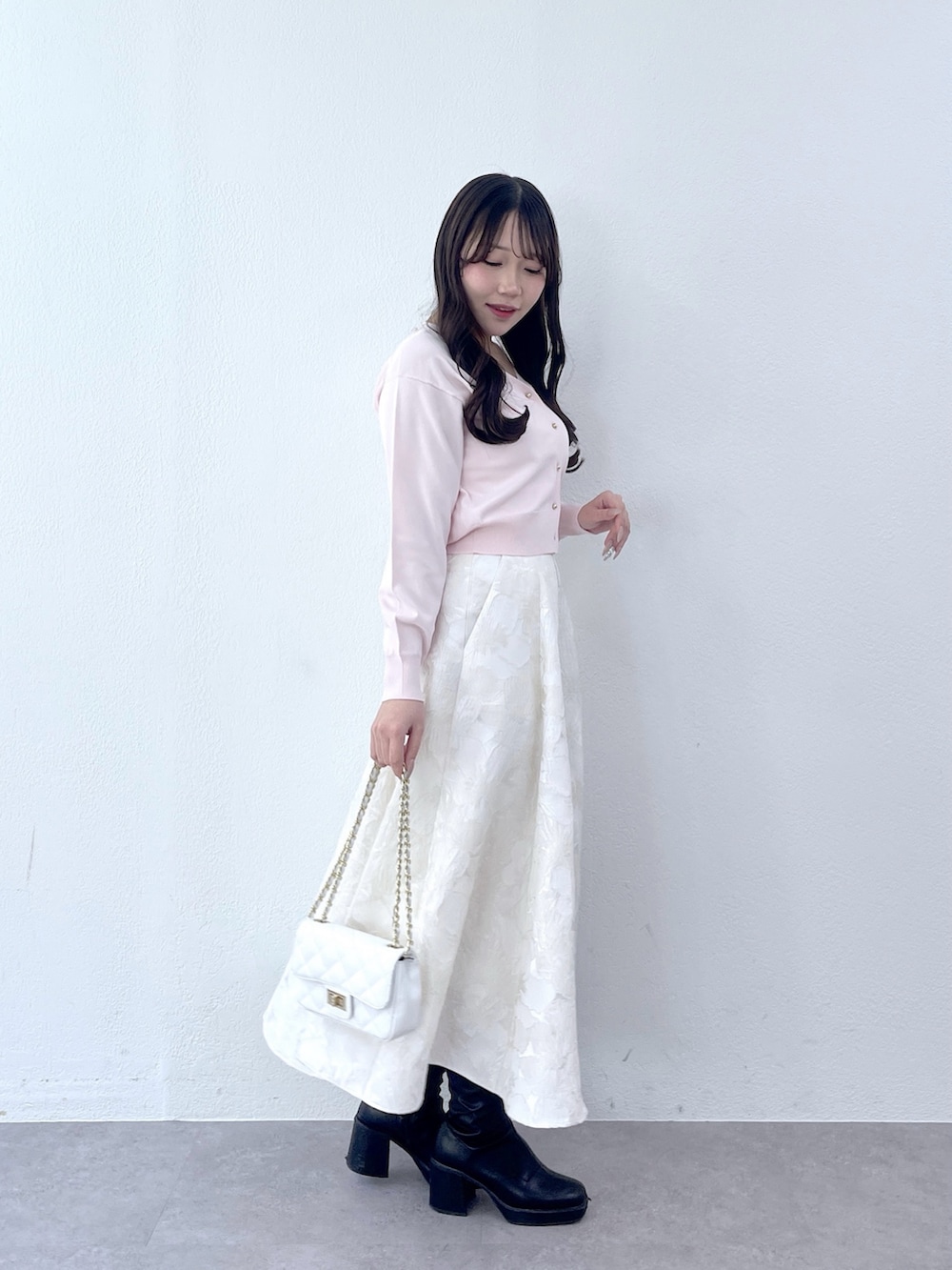 ピンク系のカーディガン/ボレロ、ホワイト系のスカートを着用したレディースの冬コーディネートの4枚目の写真