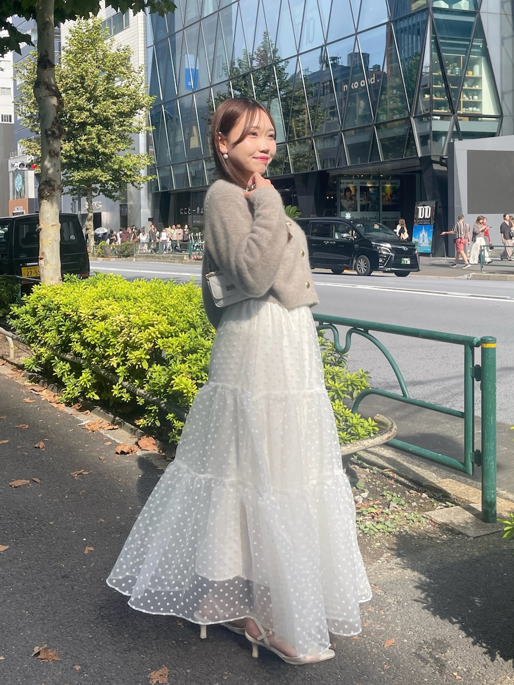 ブラウン系のカーディガン/ボレロ、ホワイト系のスカートを着用したレディースの秋コーディネートの4枚目の写真