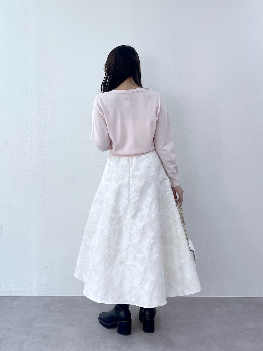 ピンク系のカーディガン/ボレロ、ホワイト系のスカートを着用したレディースの冬コーディネートの5枚目の写真