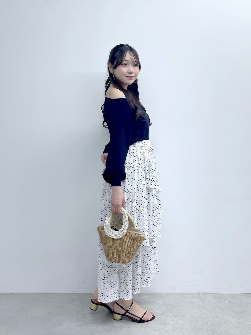 ブルー系のニット/セーター、ホワイト系のスカートを着用したレディースの春コーディネートの6枚目の写真