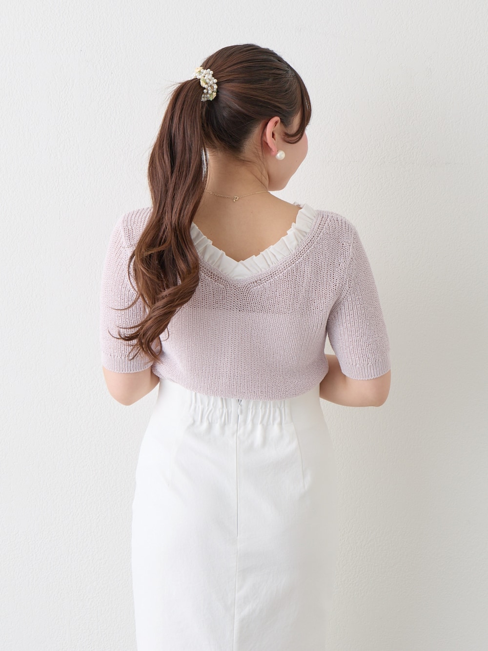 パープル系のニット/セーター、ホワイト系のスカートを着用したレディースの春コーディネートの6枚目の写真