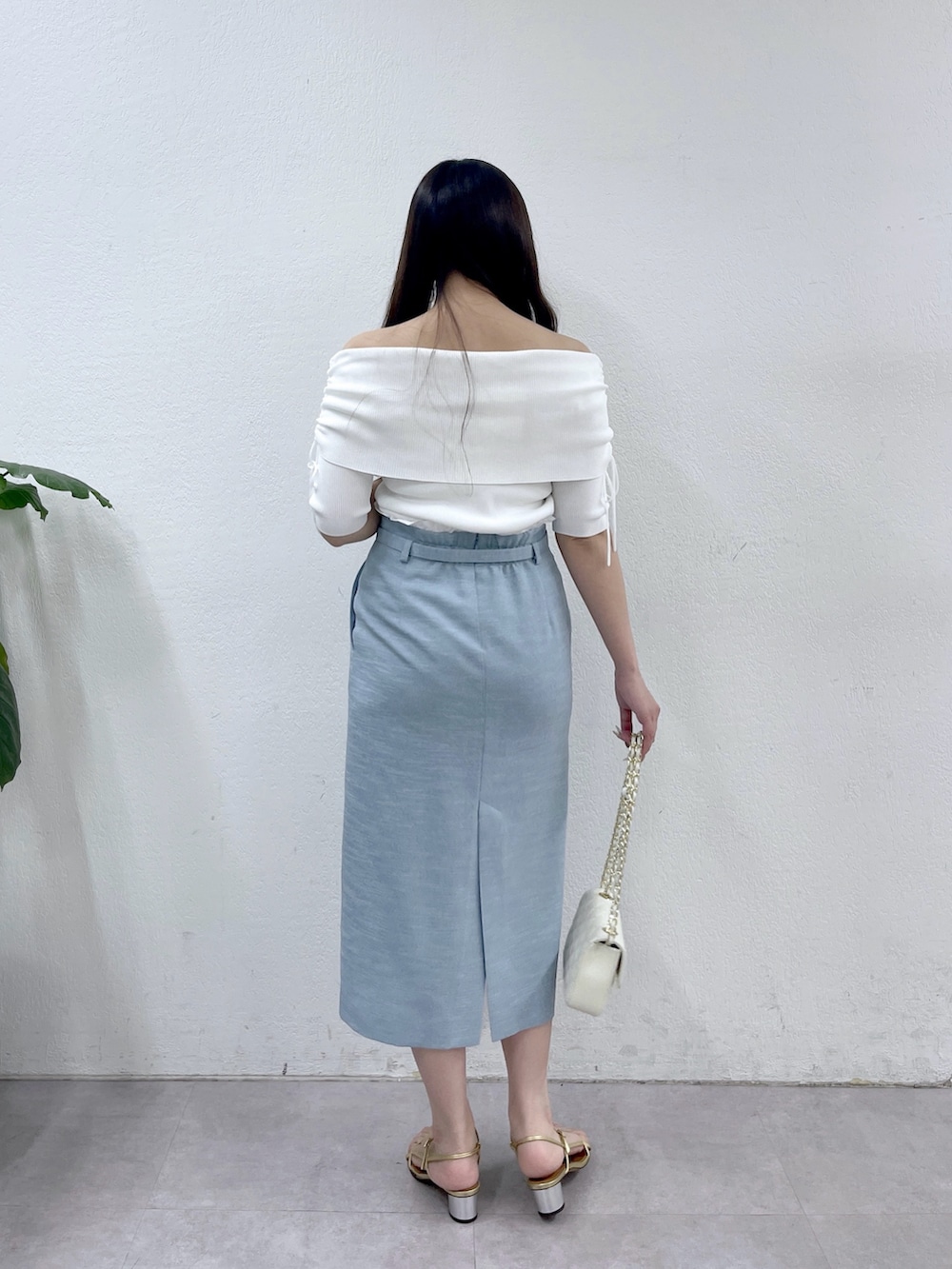 ブルー系のスカート、ホワイト系のニット/セーター、ホワイト系のトートバッグを着用したレディースの春コーディネートの3枚目の写真