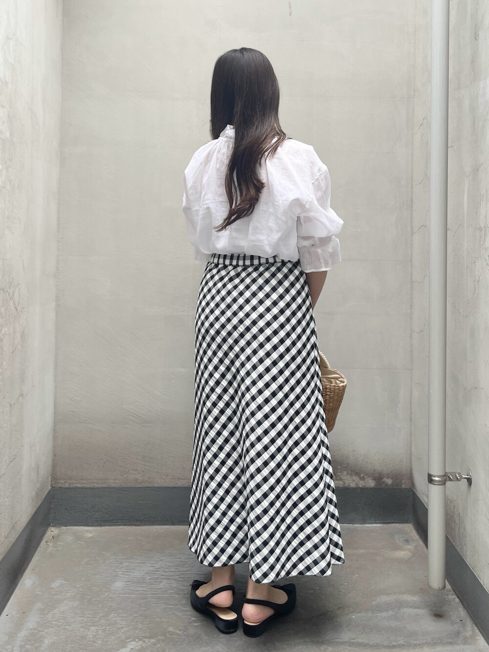 ブラック系のスカート、ホワイト系のシャツ/ブラウスを着用したレディースの夏コーディネートの2枚目の写真