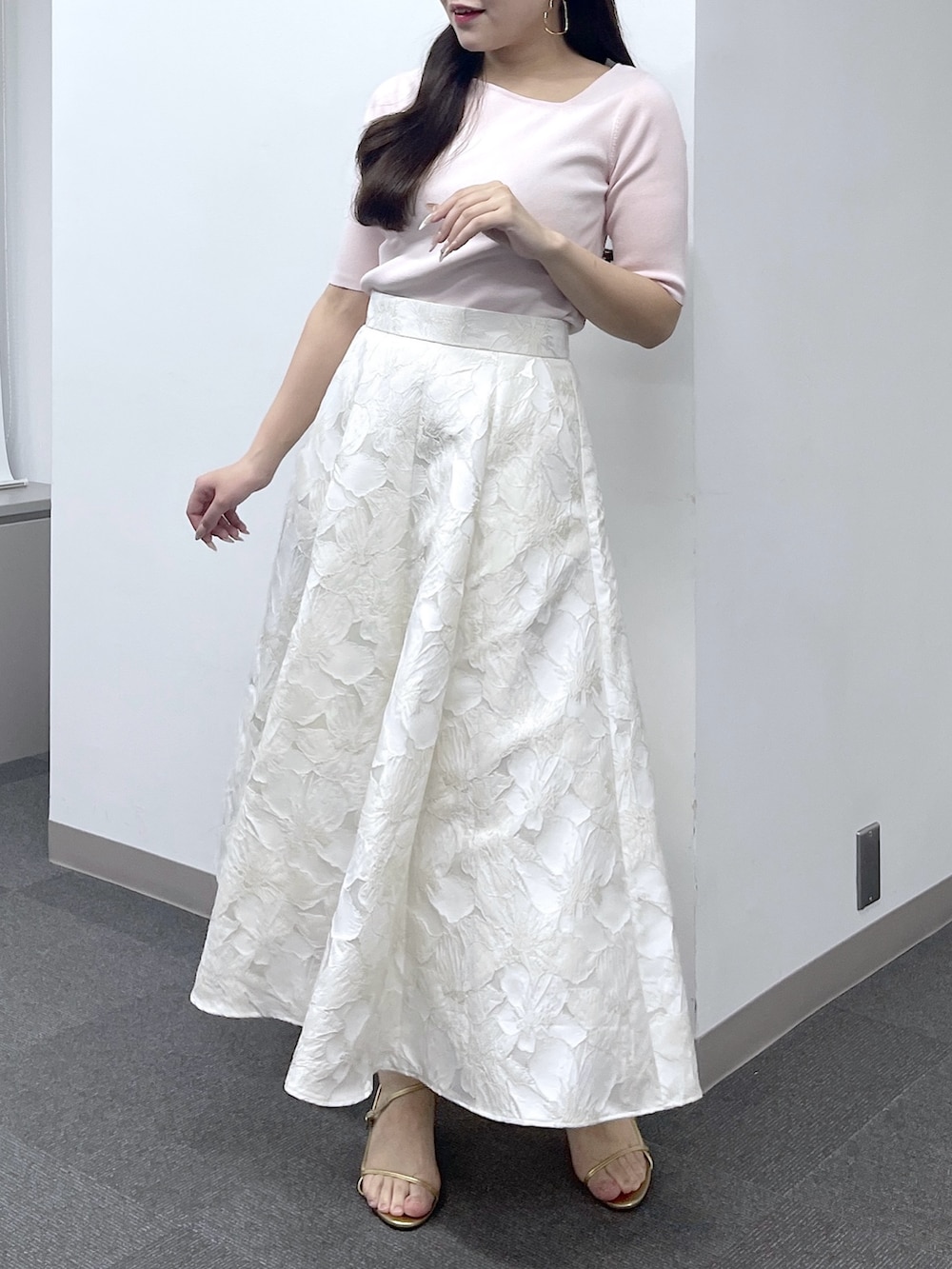 ピンク系のニット/セーター、ホワイト系のスカートを着用したレディースの春コーディネートの2枚目の写真