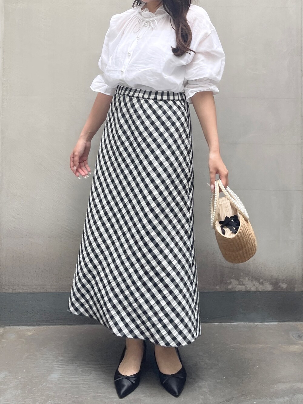 ブラック系のスカート、ホワイト系のシャツ/ブラウスを着用したレディースの夏コーディネートの5枚目の写真