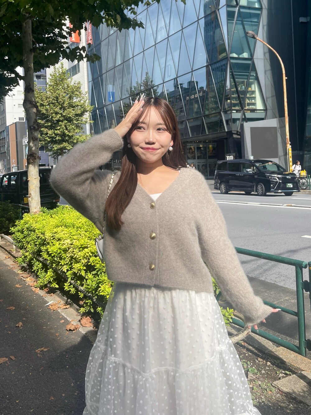 ブラウン系のカーディガン/ボレロ、ホワイト系のスカートを着用したレディースの秋コーディネートの7枚目の写真