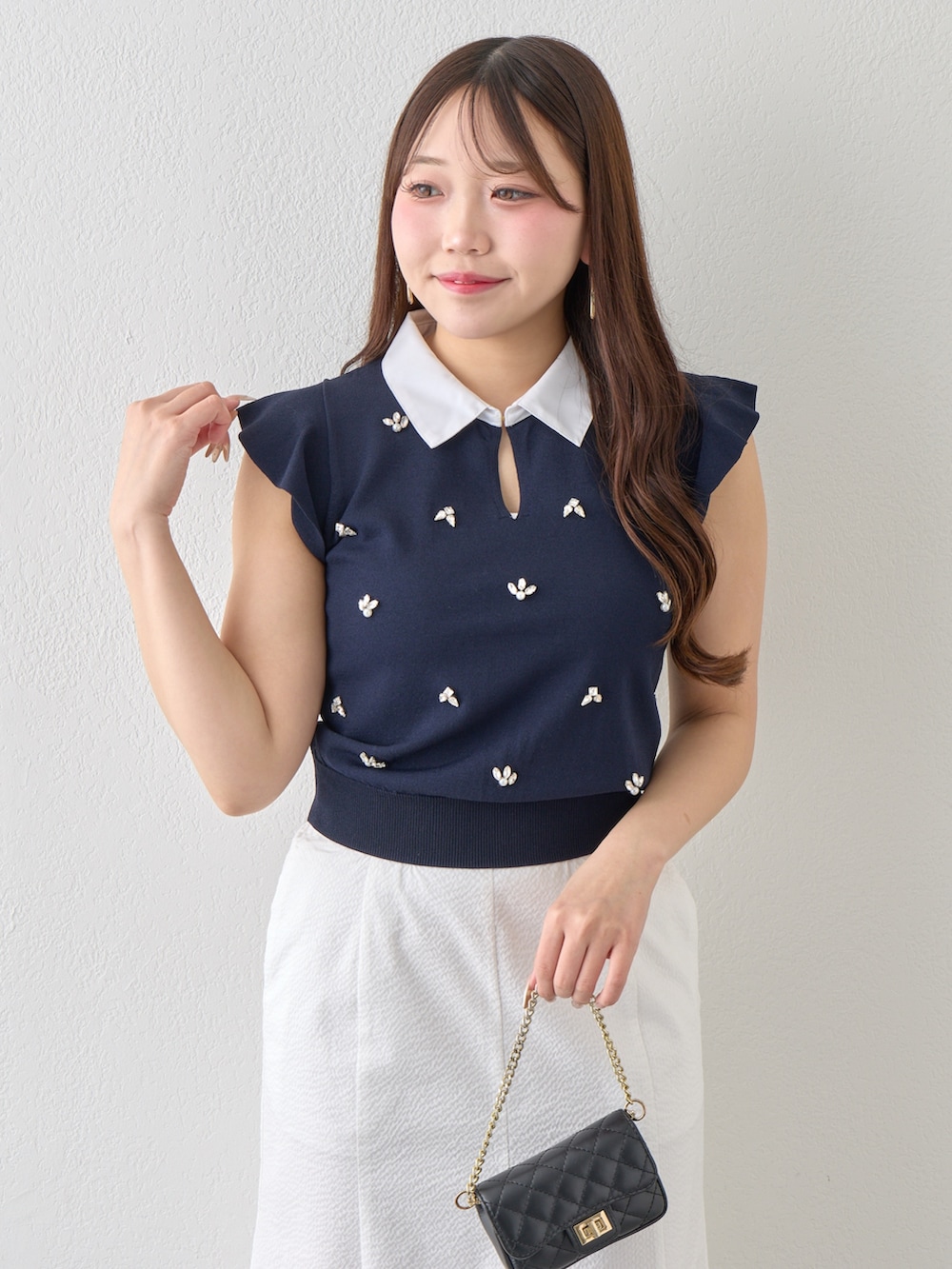 ブルー系のニット/セーター、ホワイト系のスカートを着用したレディースの春コーディネートの6枚目の写真