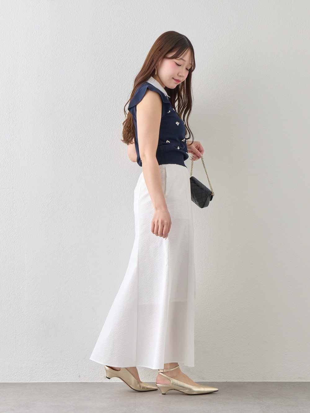 ブルー系のニット/セーター、ホワイト系のスカートを着用したレディースの春コーディネートの5枚目の写真