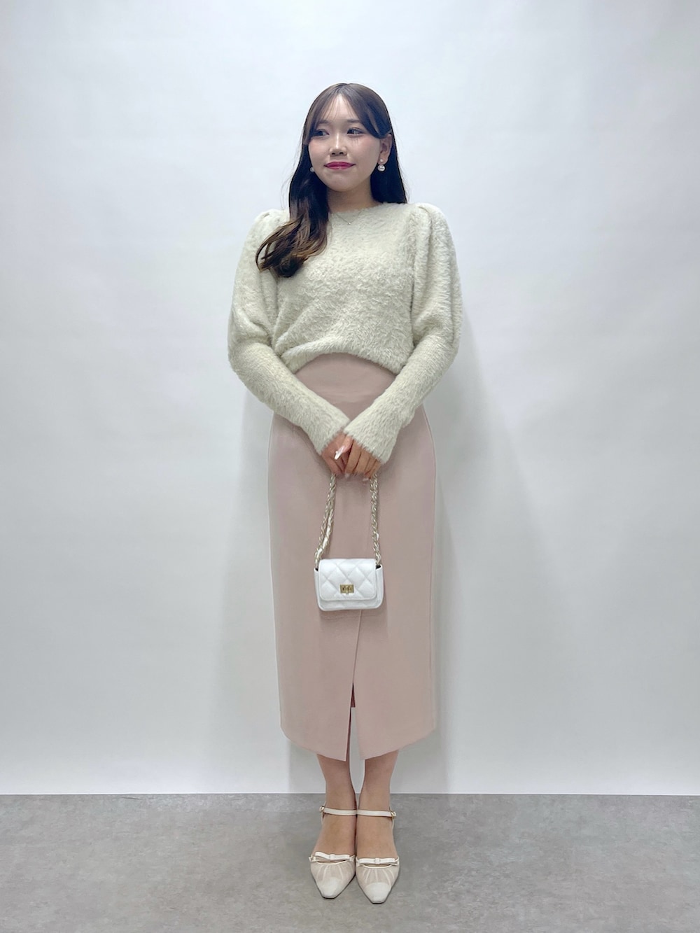 ベージュ系のニット/セーター、ピンク系のスカートを着用したレディースの秋コーディネートの2枚目の写真