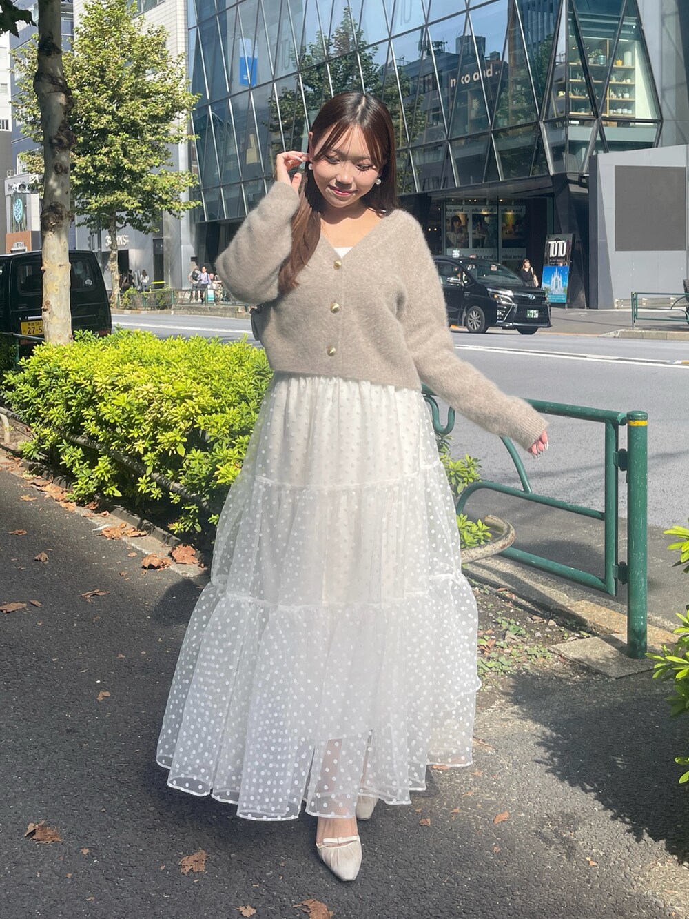 ブラウン系のカーディガン/ボレロ、ホワイト系のスカートを着用したレディースの秋コーディネートの2枚目の写真