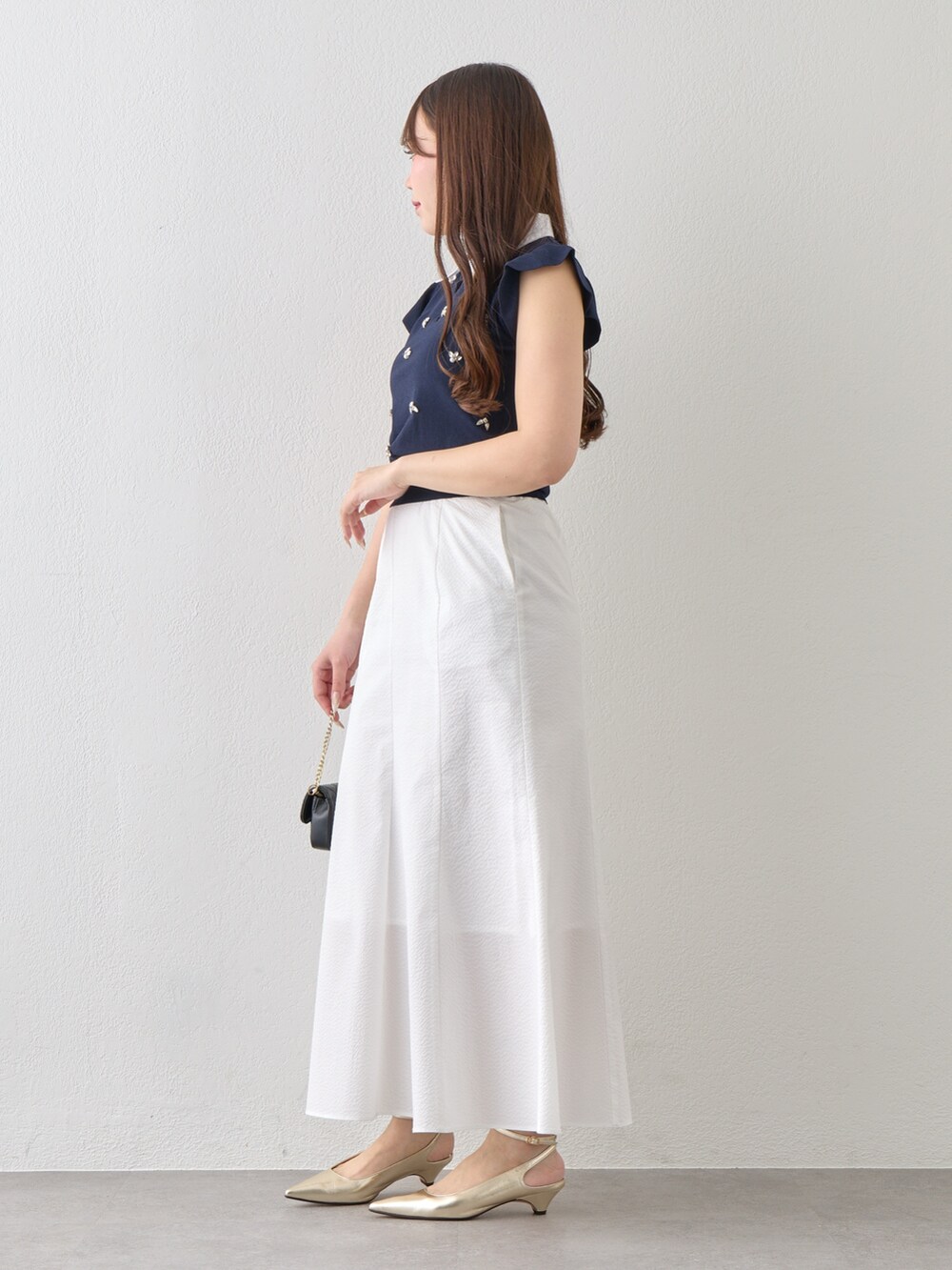 ブルー系のニット/セーター、ホワイト系のスカートを着用したレディースの春コーディネートの3枚目の写真