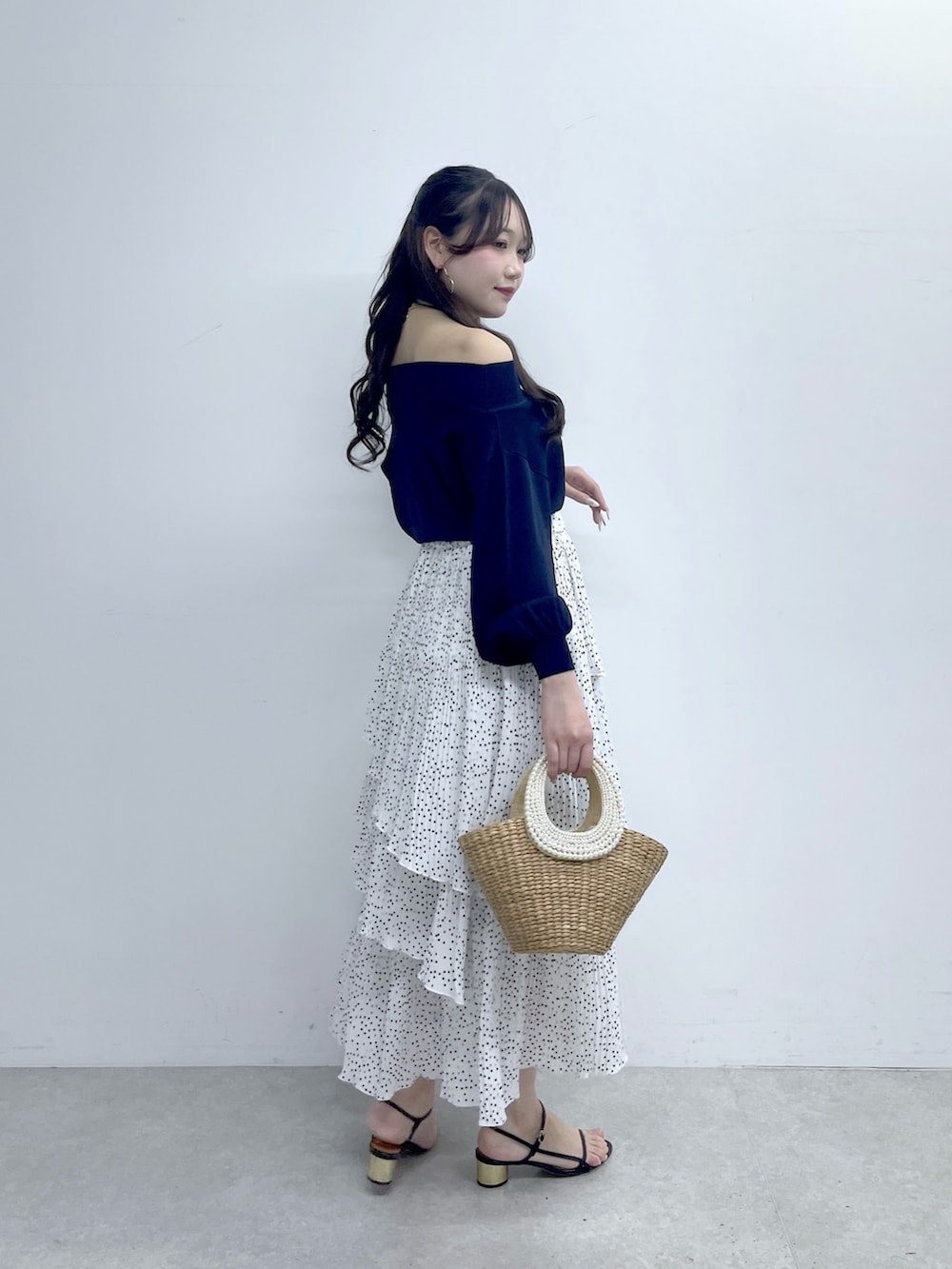 ブルー系のニット/セーター、ホワイト系のスカートを着用したレディースの春コーディネートの5枚目の写真