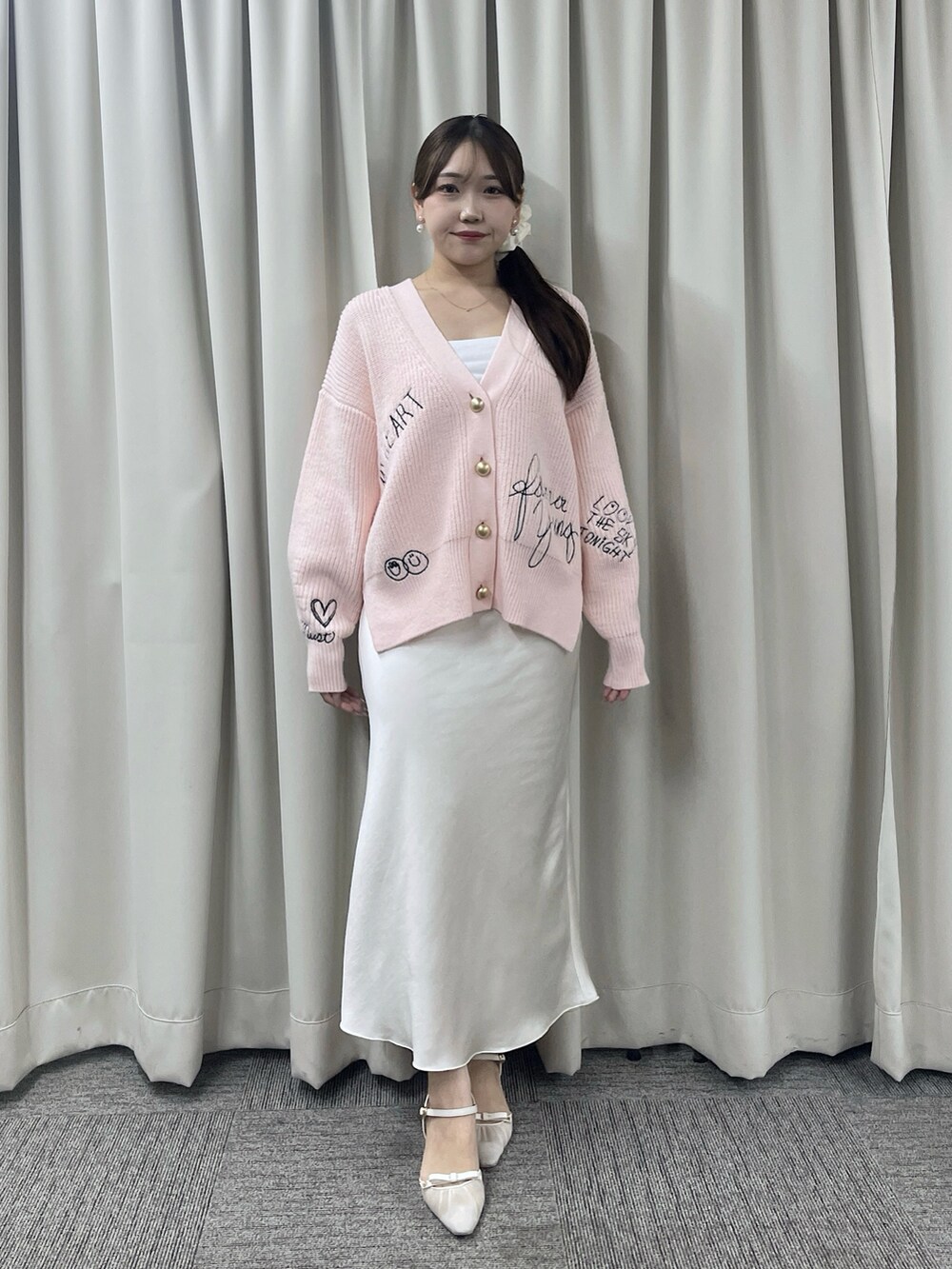 ピンク系のカーディガン/ボレロ、ホワイト系のスカートを着用したレディースの秋コーディネートの2枚目の写真