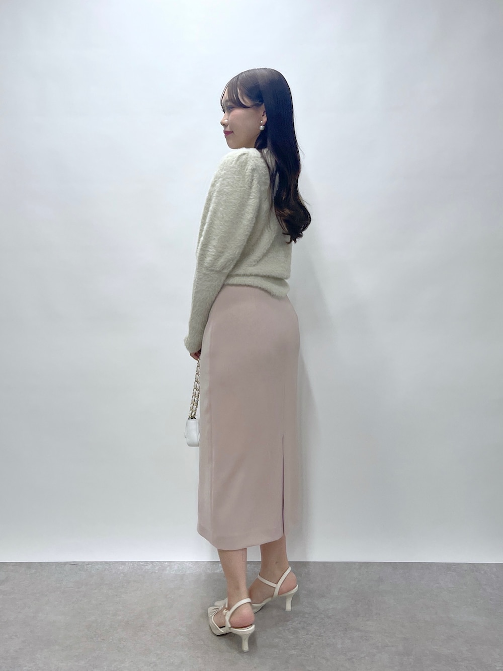 ベージュ系のニット/セーター、ピンク系のスカートを着用したレディースの秋コーディネートの6枚目の写真