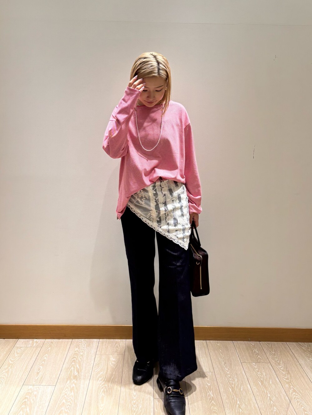 レッド系のTシャツ/カットソー、ブルー系のデニムパンツ、ブラウン系のショルダーバッグを着用したレディースの秋コーディネートの4枚目の写真