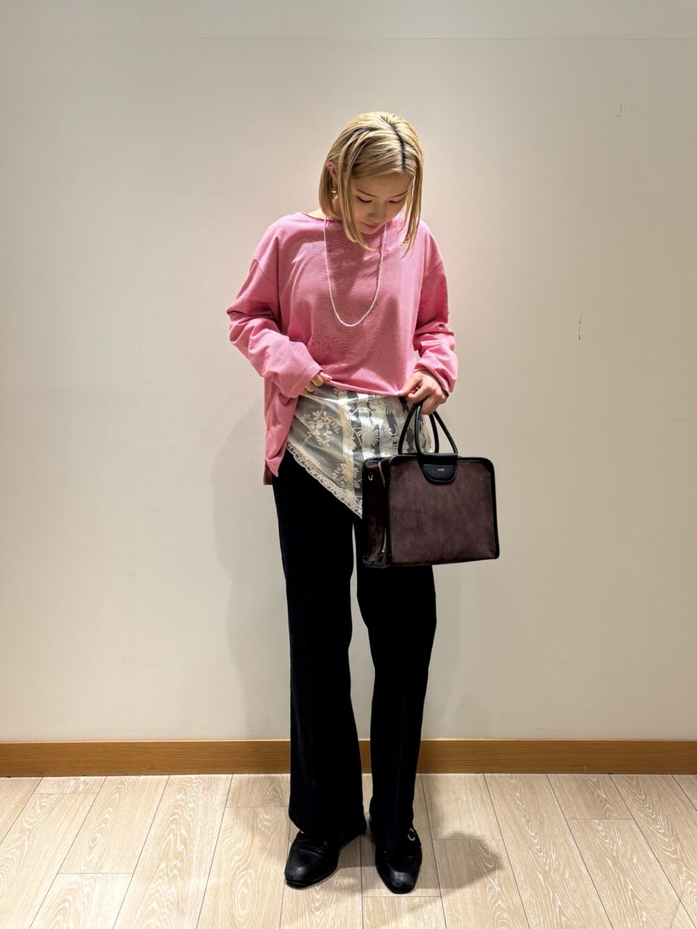 レッド系のTシャツ/カットソー、ブルー系のデニムパンツ、ブラウン系のショルダーバッグを着用したレディースの秋コーディネートの2枚目の写真