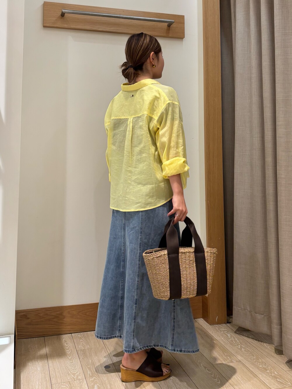 ブラウン系のTシャツ/カットソー、イエロー系のシャツ/ブラウス、ブルー系のデニムスカートを着用したレディースの夏コーディネートの2枚目の写真