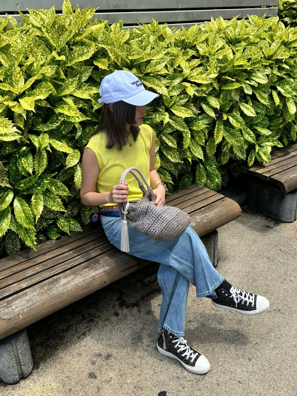 イエロー系のタンクトップ、ブルー系のデニムパンツ、ベージュ系のかごバッグを着用したレディースの夏コーディネートの6枚目の写真