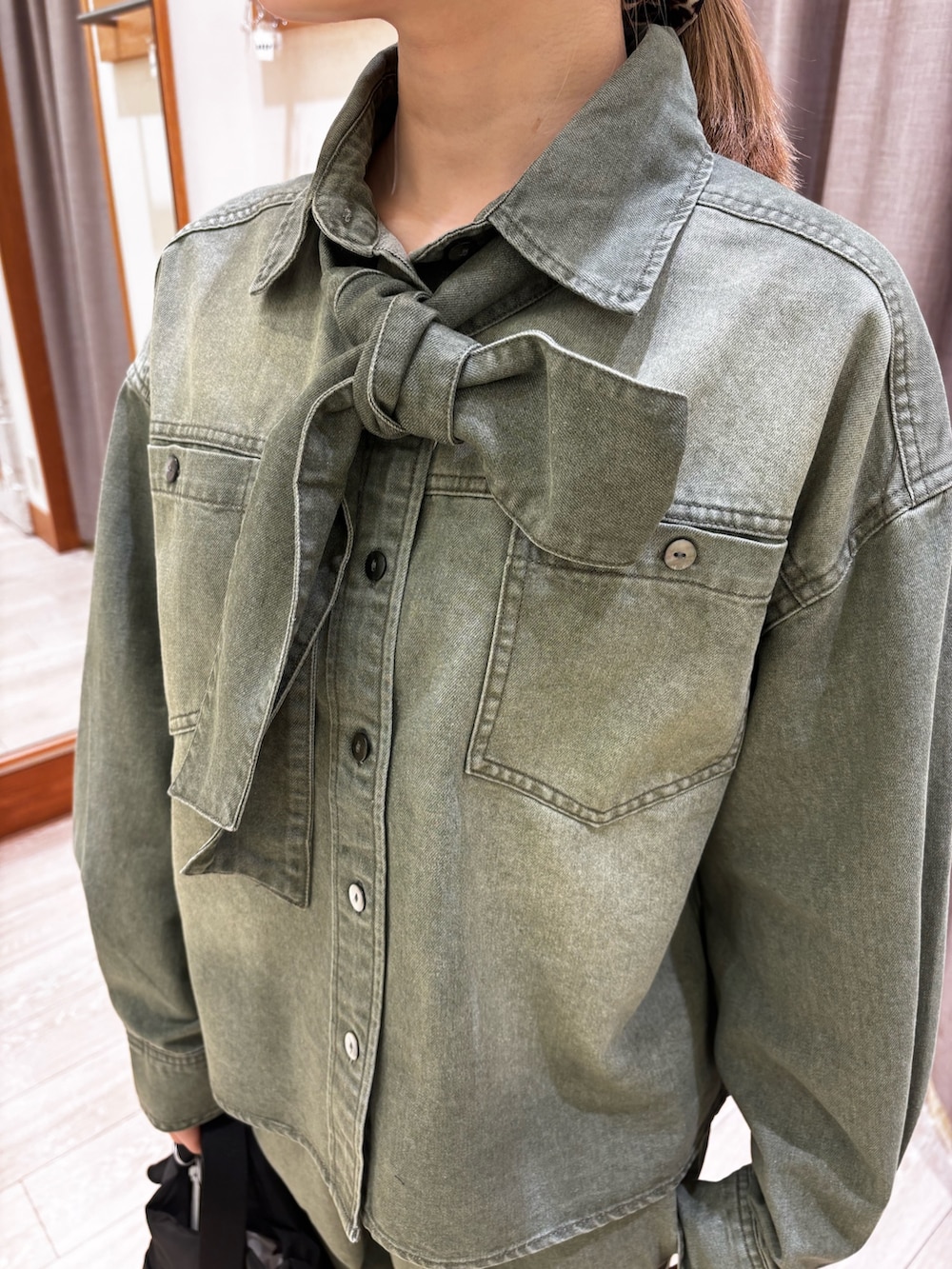 グリーン系のシャツ/ブラウス、グリーン系のデニムパンツ、ブラック系のショルダーバッグを着用したレディースの春コーディネートの5枚目の写真