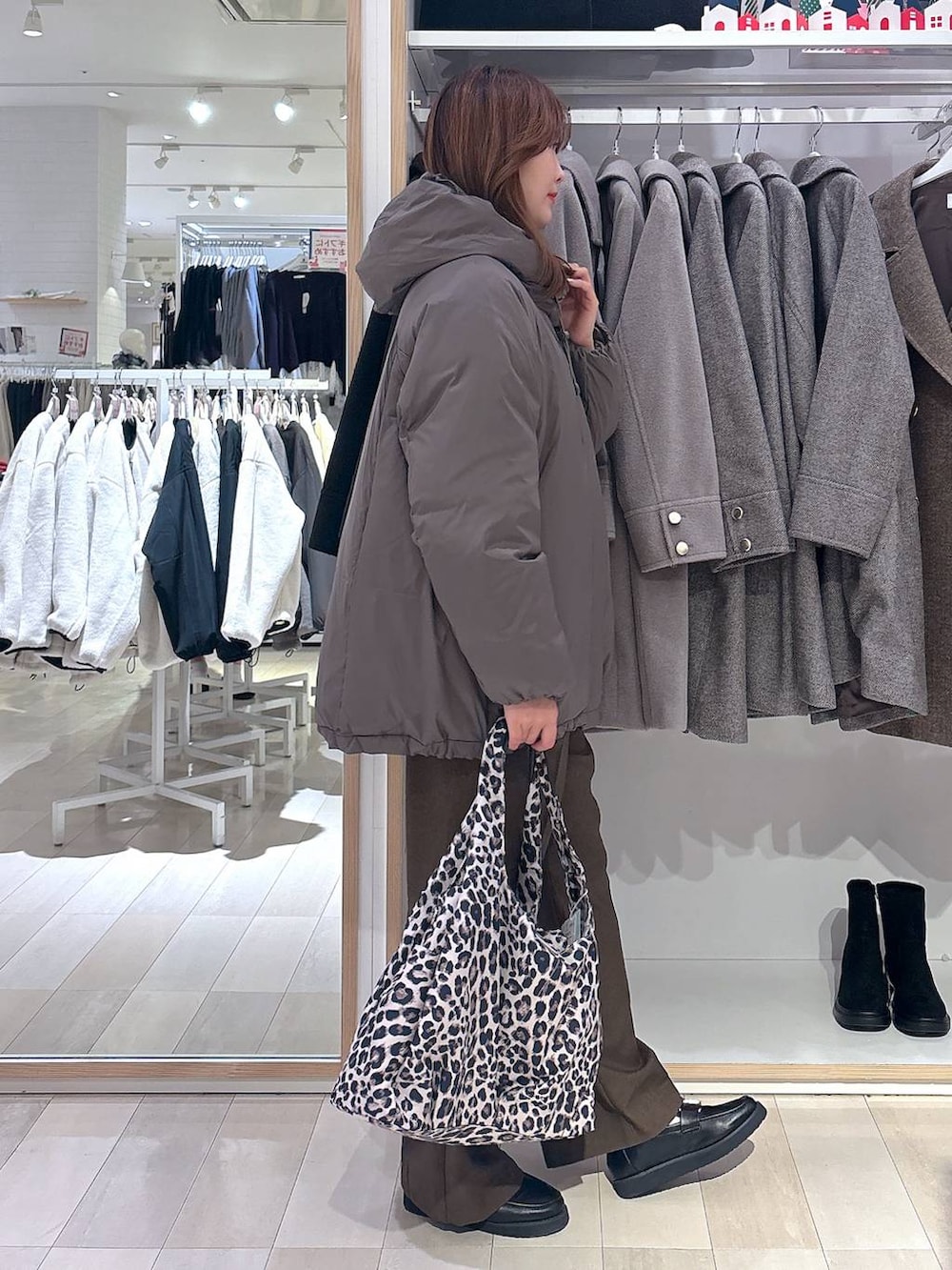 ブラック系のローファー、その他のトートバッグ、ブラウン系のダウンジャケット/コートを着用したレディースの冬コーディネートの4枚目の写真