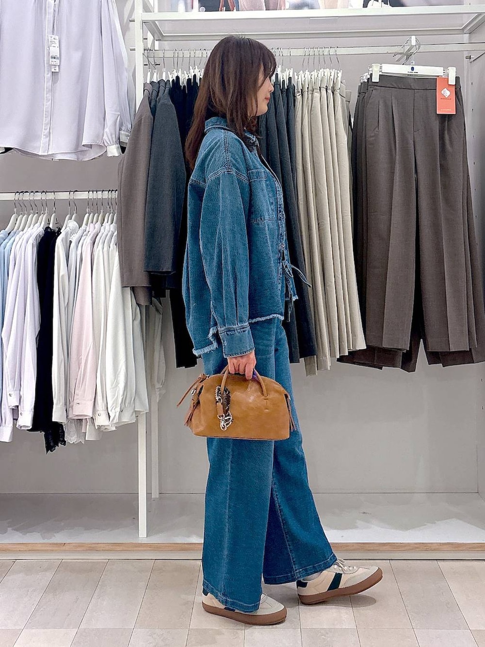 ベージュ系のスニーカー、ブルー系のシャツ/ブラウス、ブルー系のデニムパンツを着用したレディースの春コーディネートの4枚目の写真