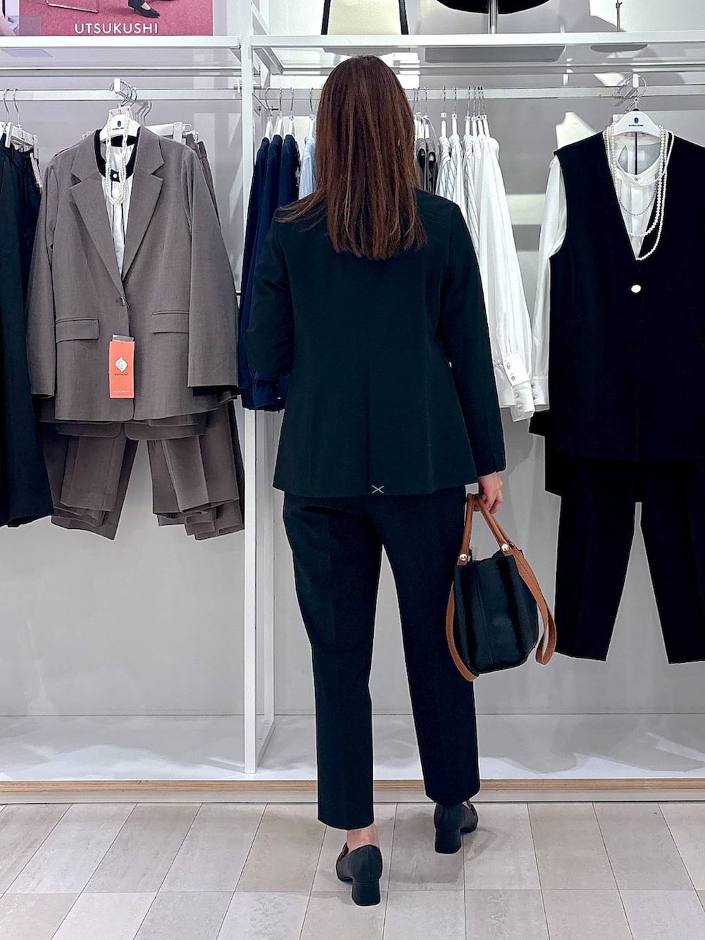 ブラック系のローファー、ブラック系のスラックス、ホワイト系のシャツ/ブラウスを着用したレディースの冬コーディネートの3枚目の写真