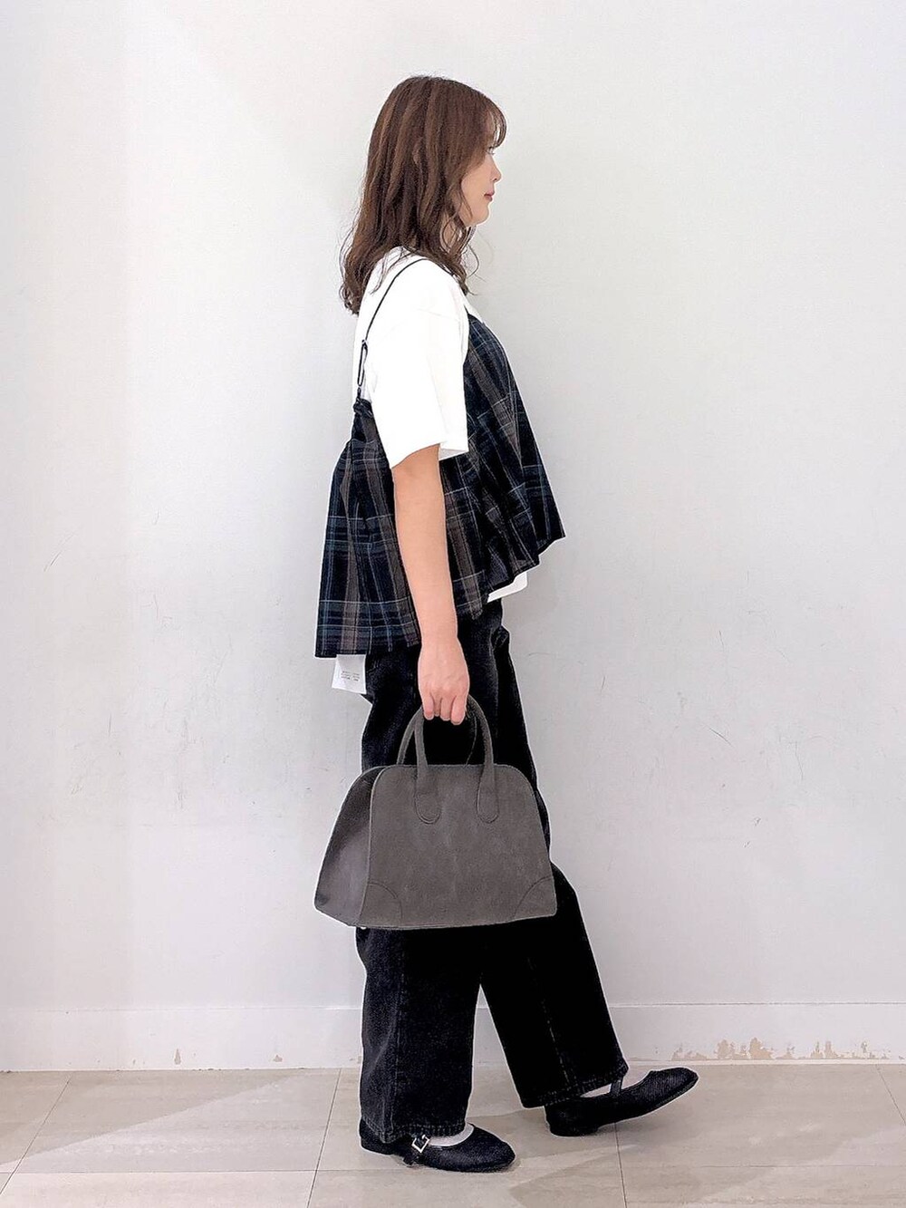 ブラック系のデニムパンツ、ホワイト系のTシャツ/カットソー、ブラック系のキャミソールを着用したレディースの秋コーディネートの4枚目の写真