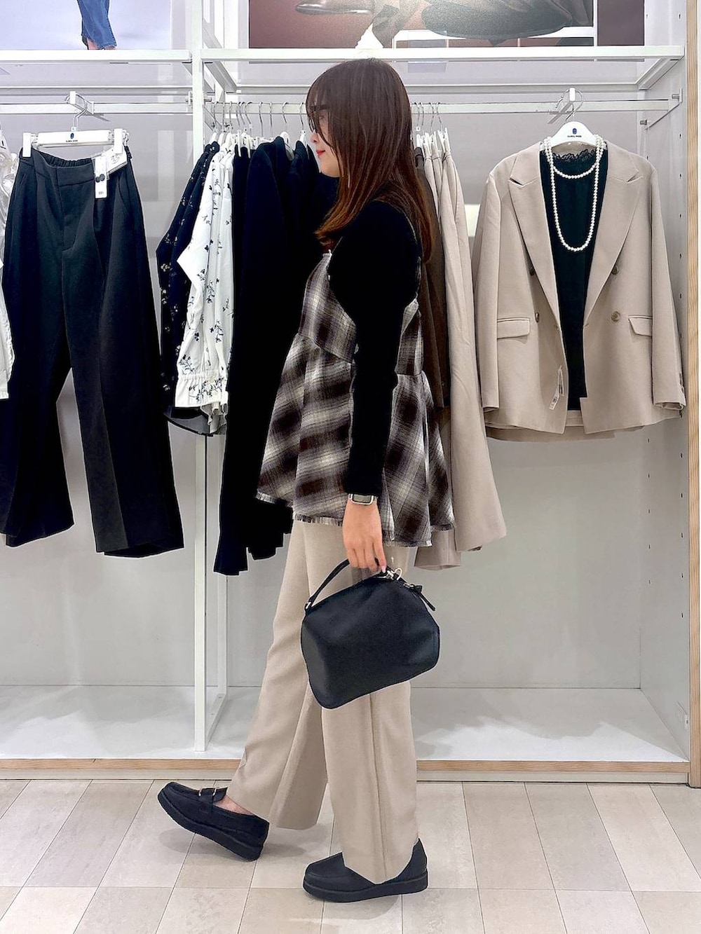 ブラック系のショルダーバッグ、ブラック系のローファー、ブラック系のニット/セーターを着用したレディースの冬コーディネートの2枚目の写真