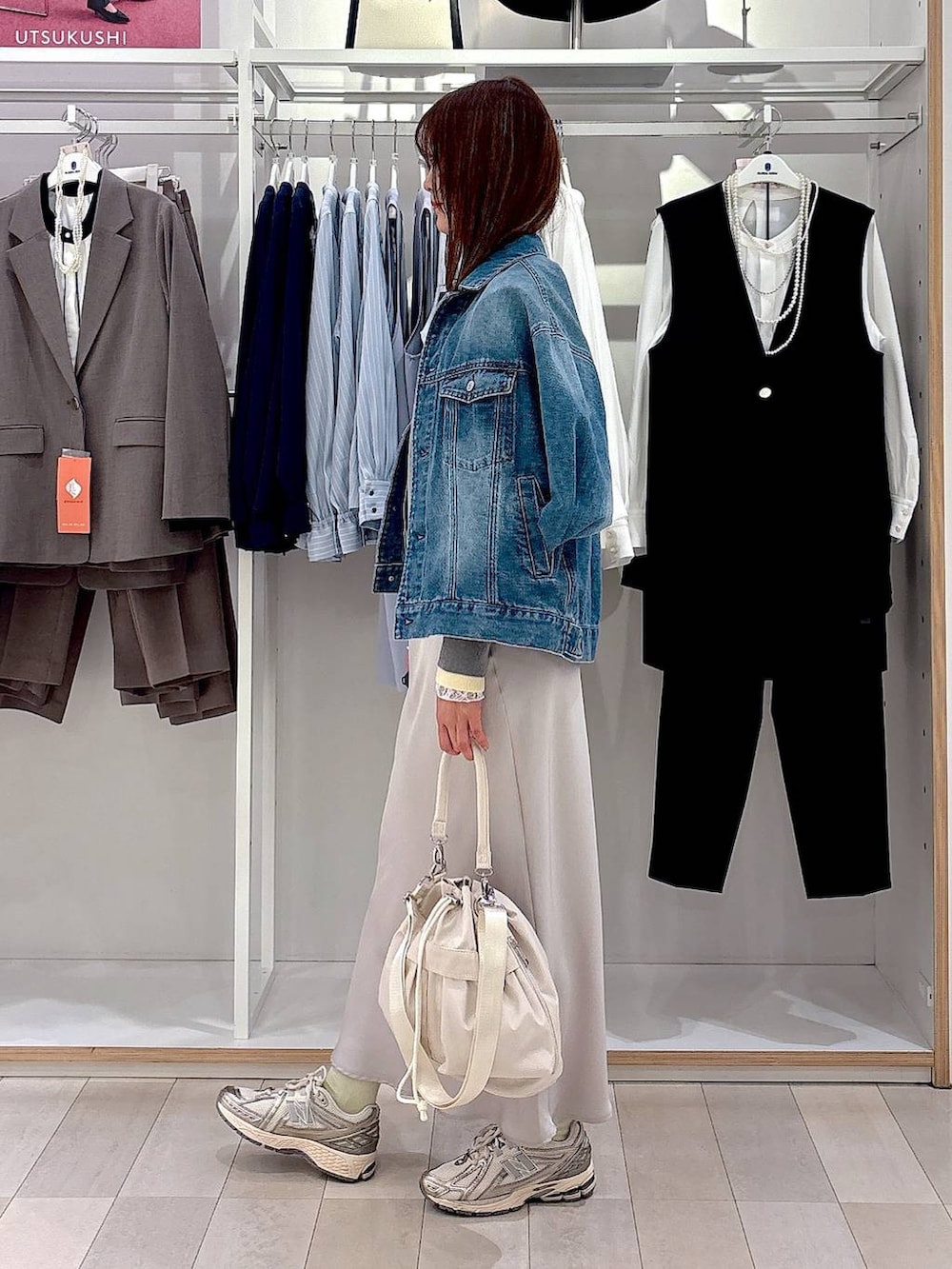 ホワイト系のショルダーバッグ、ホワイト系のTシャツ/カットソー、ブルー系のデニムジャケットを着用したレディースの冬コーディネートの2枚目の写真