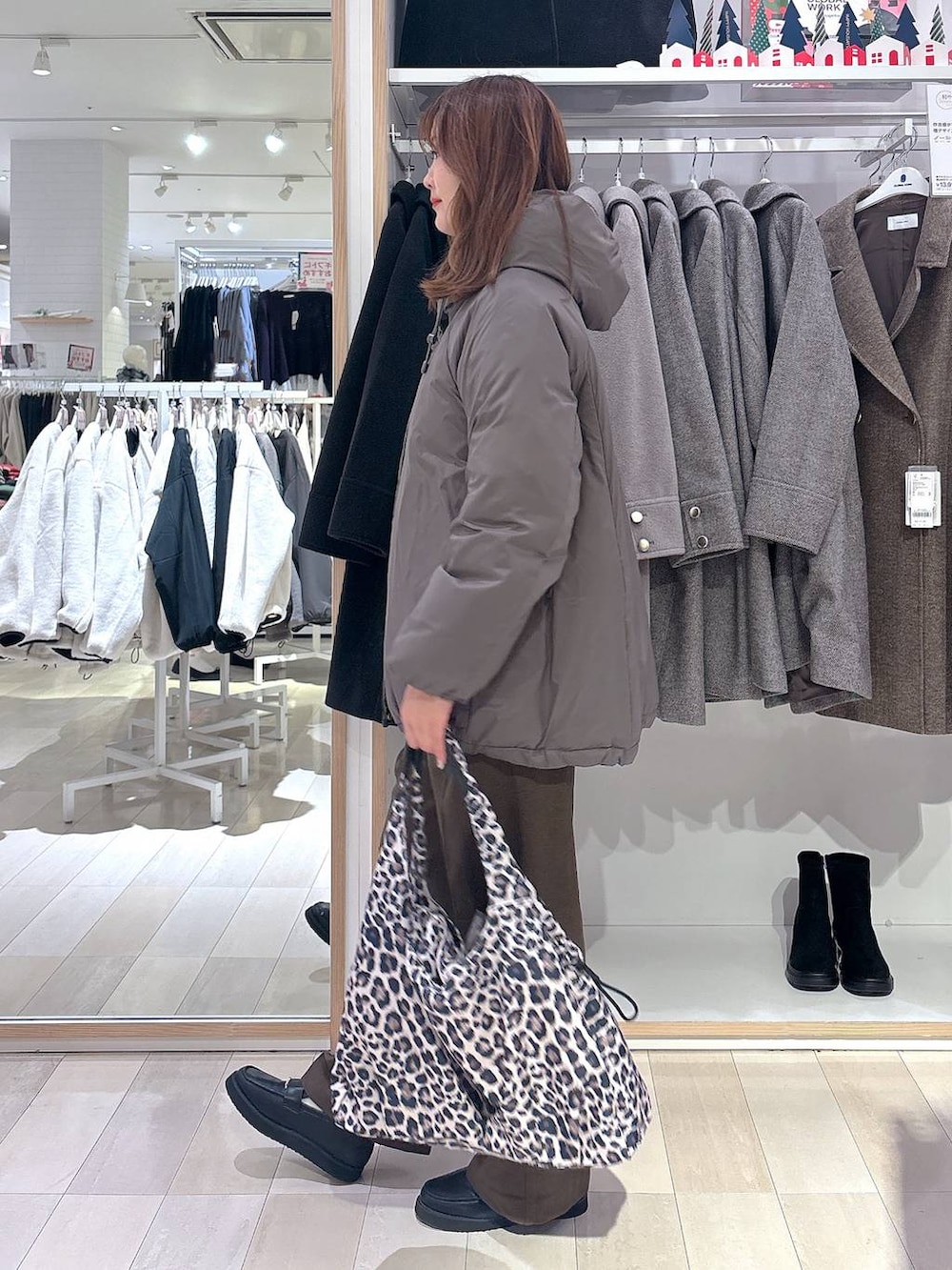 ブラック系のローファー、その他のトートバッグ、ブラウン系のダウンジャケット/コートを着用したレディースの冬コーディネートの2枚目の写真