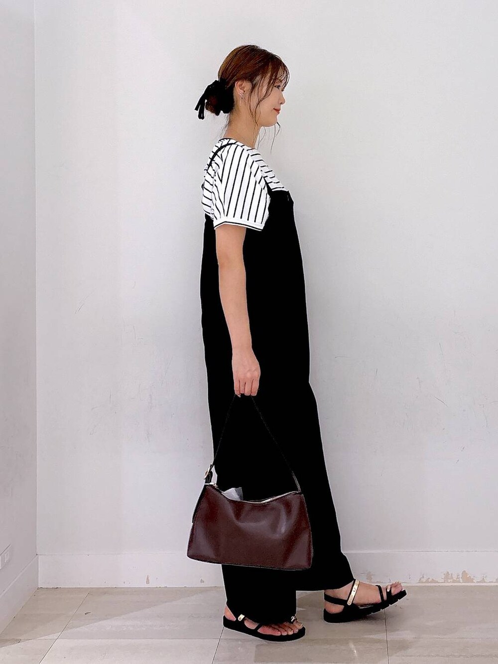 ブラウン系のショルダーバッグ、ブラック系のつなぎ/オールインワン、ホワイト系のTシャツ/カットソーを着用したレディースの夏コーディネートの4枚目の写真