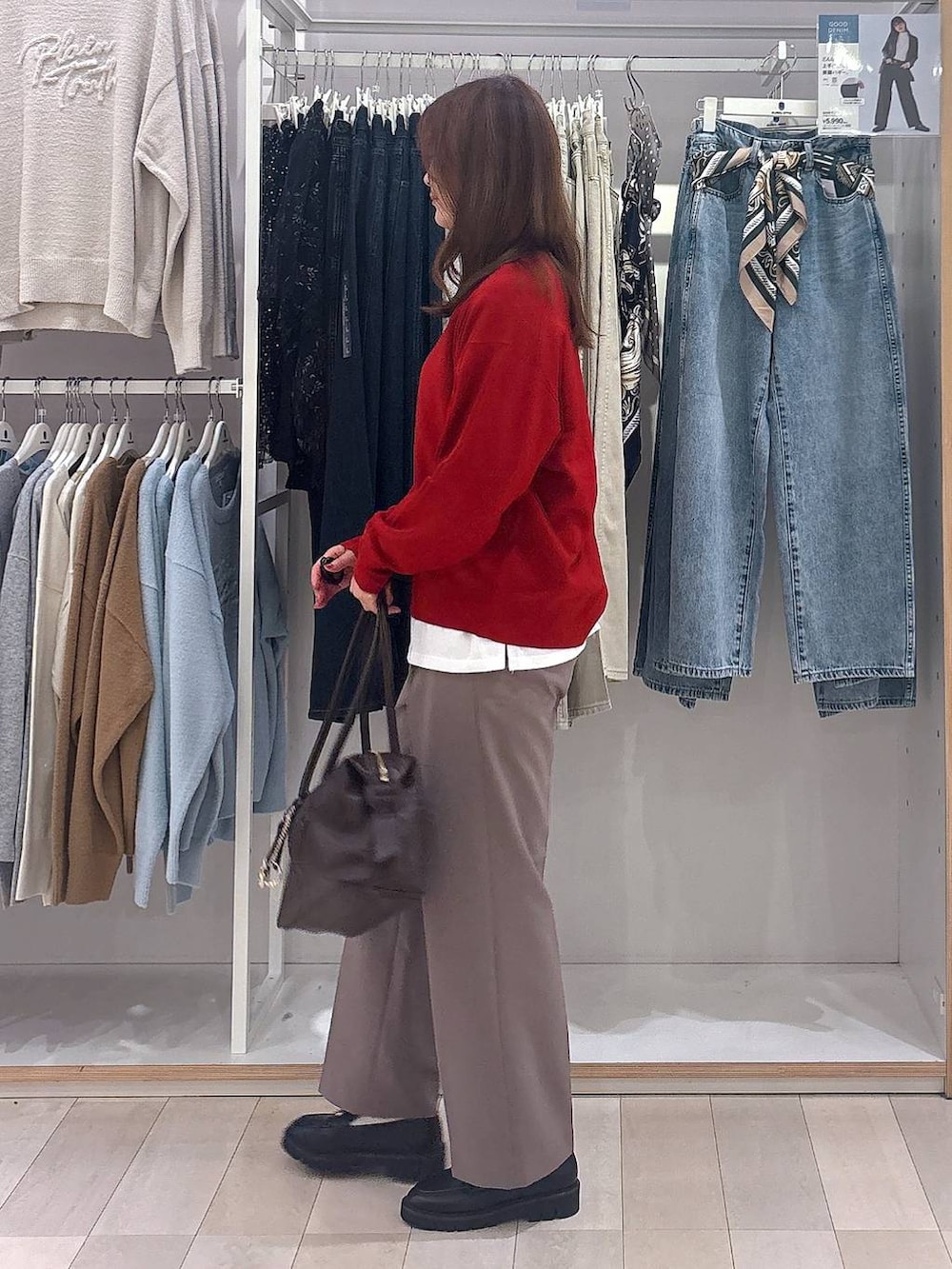 ブラウン系のボストンバッグ、ブラウン系のスラックス、ブラック系のローファーを着用したレディースの秋コーディネートの2枚目の写真