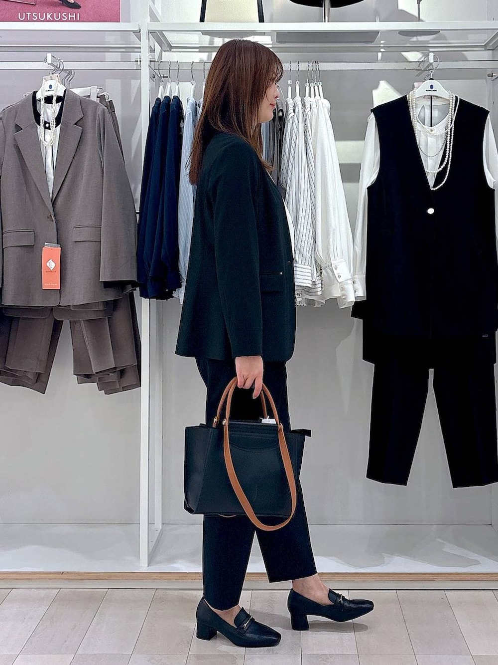 ブラック系のローファー、ブラック系のスラックス、ホワイト系のシャツ/ブラウスを着用したレディースの冬コーディネートの4枚目の写真