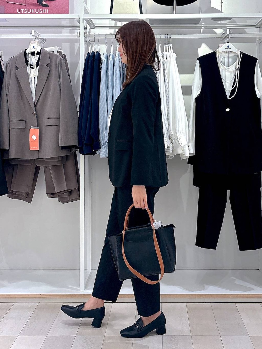 ブラック系のローファー、ブラック系のスラックス、ホワイト系のシャツ/ブラウスを着用したレディースの冬コーディネートの2枚目の写真