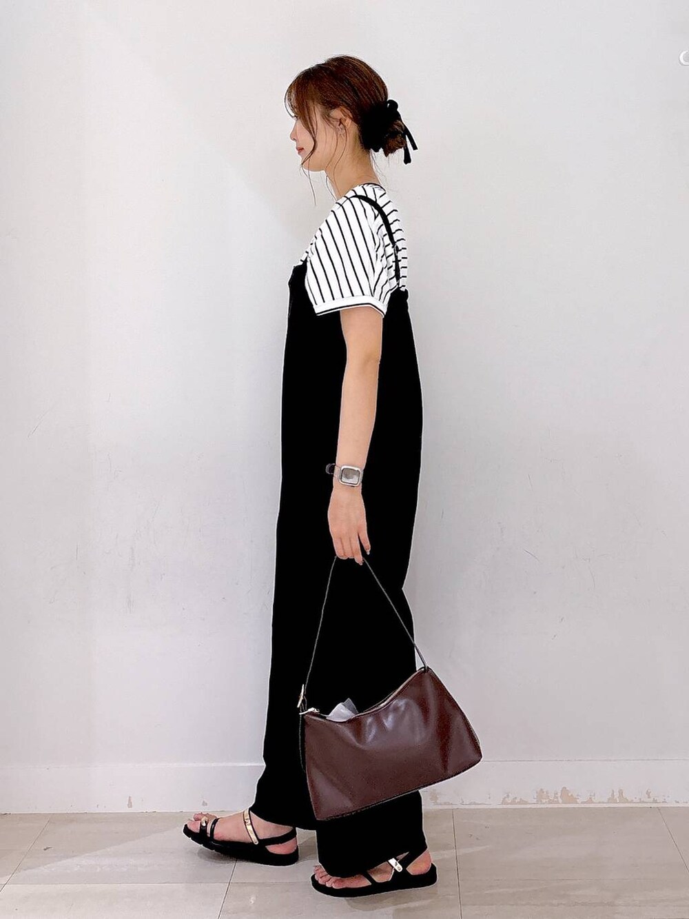ブラウン系のショルダーバッグ、ブラック系のつなぎ/オールインワン、ホワイト系のTシャツ/カットソーを着用したレディースの夏コーディネートの2枚目の写真