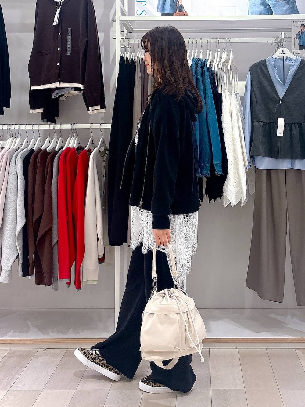 ホワイト系のショルダーバッグ、ホワイト系のその他トップス、ブラック系のパーカーを着用したレディースの春コーディネートの2枚目の写真