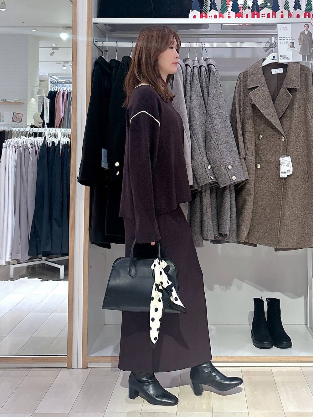 ブラック系のショルダーバッグ、ブラウン系のワンピース、ブラック系のブーツを着用したレディースの冬コーディネートの4枚目の写真