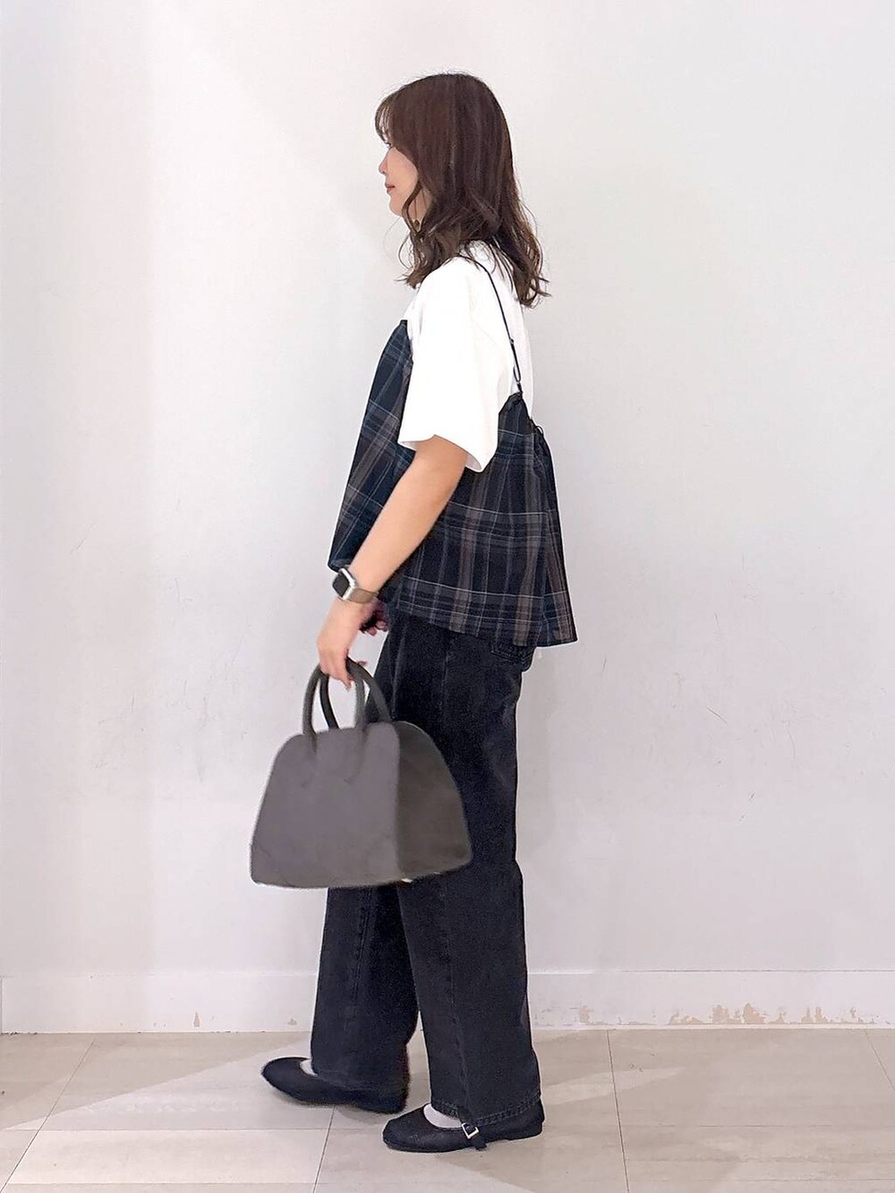 ブラック系のデニムパンツ、ホワイト系のTシャツ/カットソー、ブラック系のキャミソールを着用したレディースの秋コーディネートの2枚目の写真