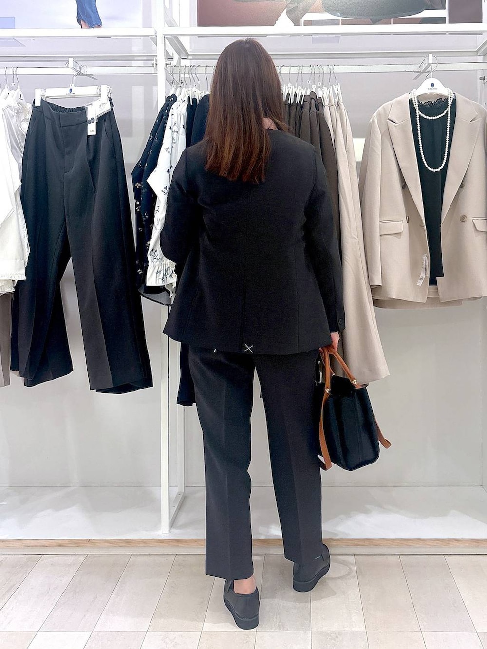 ブラック系のローファー、ブラック系のトートバッグ、グレー系のその他パンツを着用したレディースの冬コーディネートの3枚目の写真