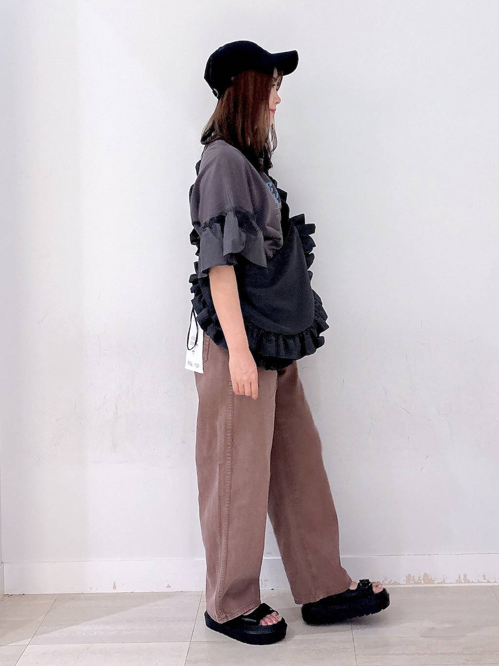 グレー系のショルダーバッグ、ブラウン系のデニムパンツ、ブラック系のサンダルを着用したレディースの秋コーディネートの4枚目の写真