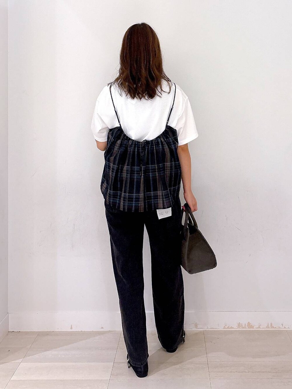 ブラック系のデニムパンツ、ホワイト系のTシャツ/カットソー、ブラック系のキャミソールを着用したレディースの秋コーディネートの3枚目の写真