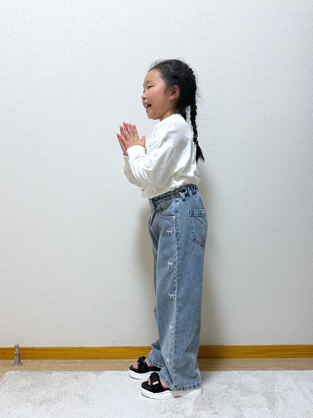 ブルー系のデニムパンツ、ブラック系のサンダル、ホワイト系のTシャツ/カットソーを着用したキッズの秋コーディネートの2枚目の写真