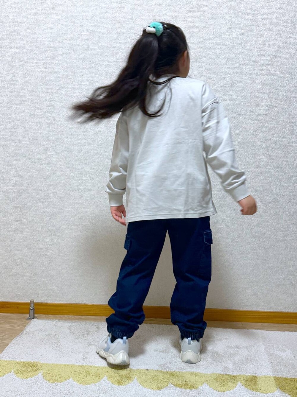 ブルー系のカーゴパンツ、ホワイト系のスニーカー、グレー系のTシャツ/カットソーを着用したキッズの冬コーディネートの3枚目の写真