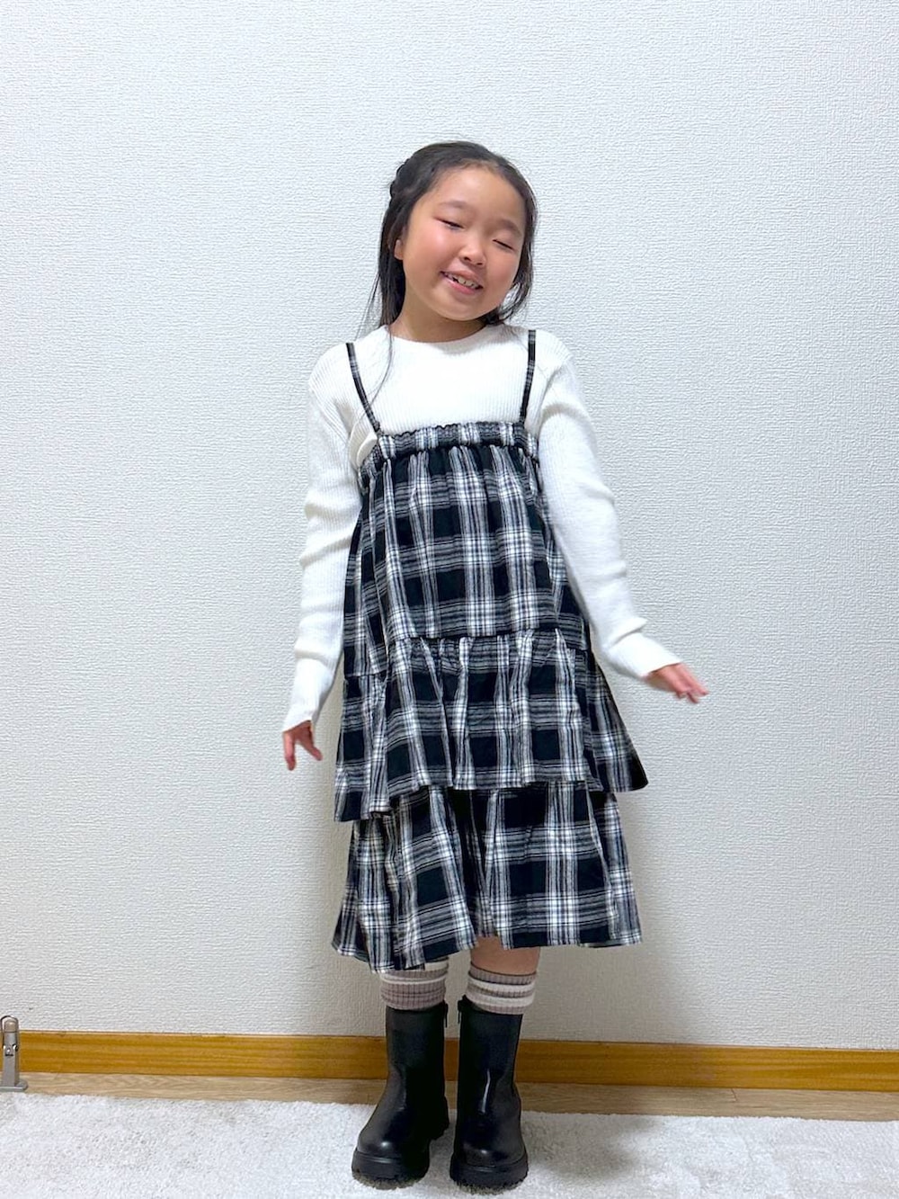 ホワイト系のニット/セーター、ブラック系のブーツ、ブラック系のスカートを着用したキッズの秋コーディネートの4枚目の写真