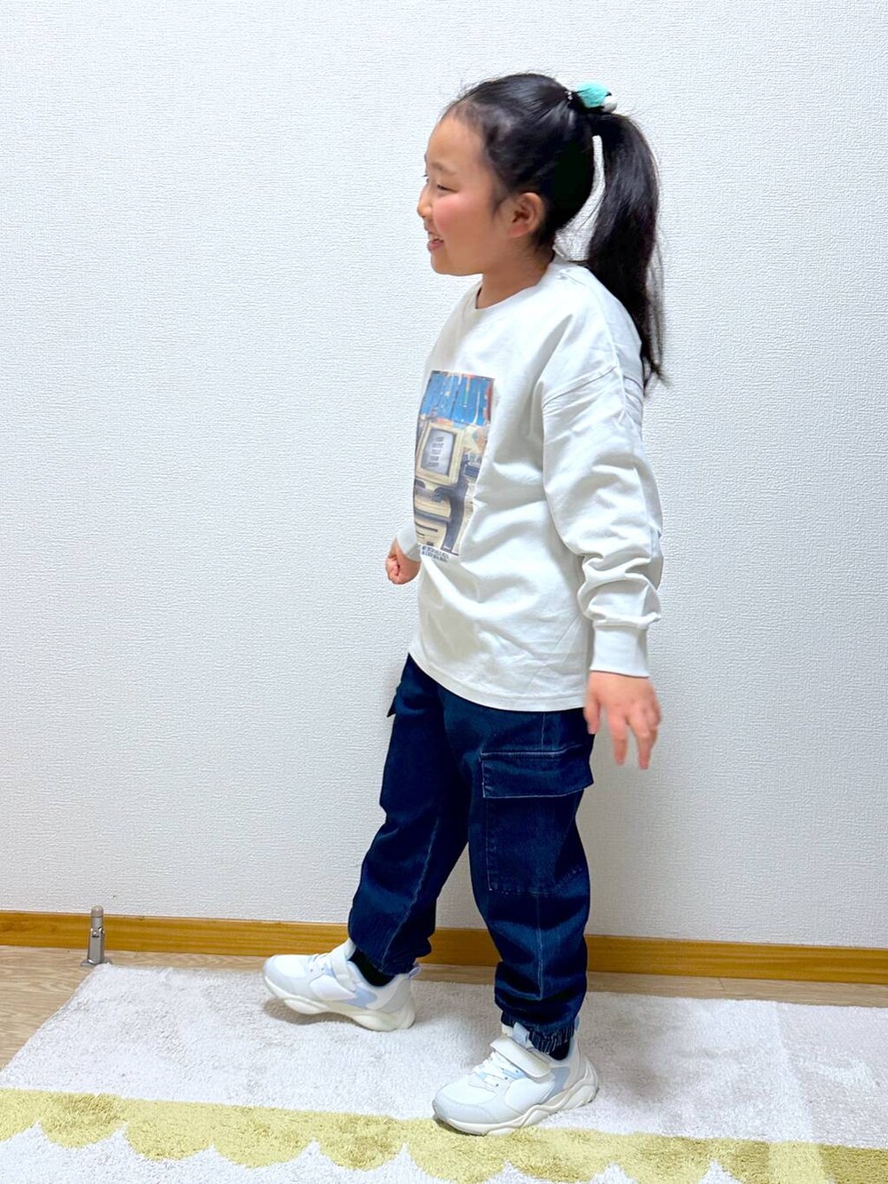ブルー系のカーゴパンツ、ホワイト系のスニーカー、グレー系のTシャツ/カットソーを着用したキッズの冬コーディネートの2枚目の写真