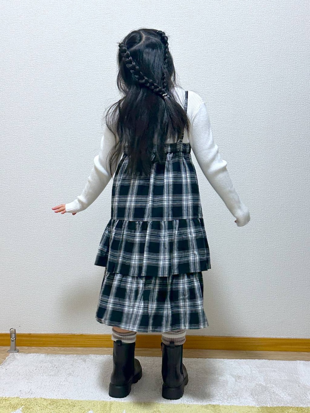 ホワイト系のニット/セーター、ブラック系のブーツ、ブラック系のスカートを着用したキッズの秋コーディネートの3枚目の写真