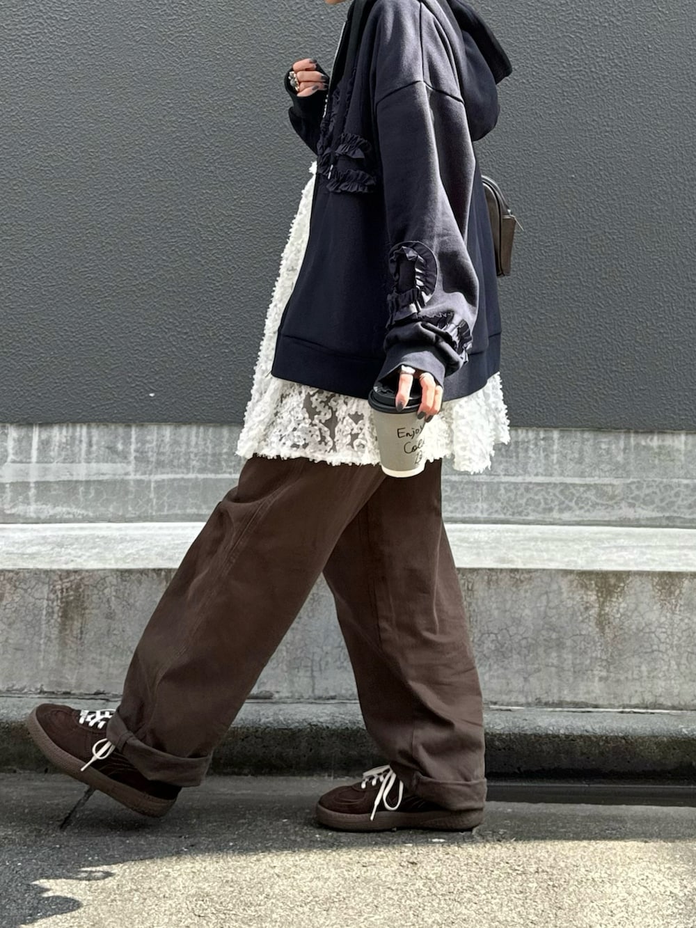 ホワイト系のチュニック、ブラウン系のスニーカー、ブルー系のパーカーを着用したレディースの秋コーディネートの3枚目の写真