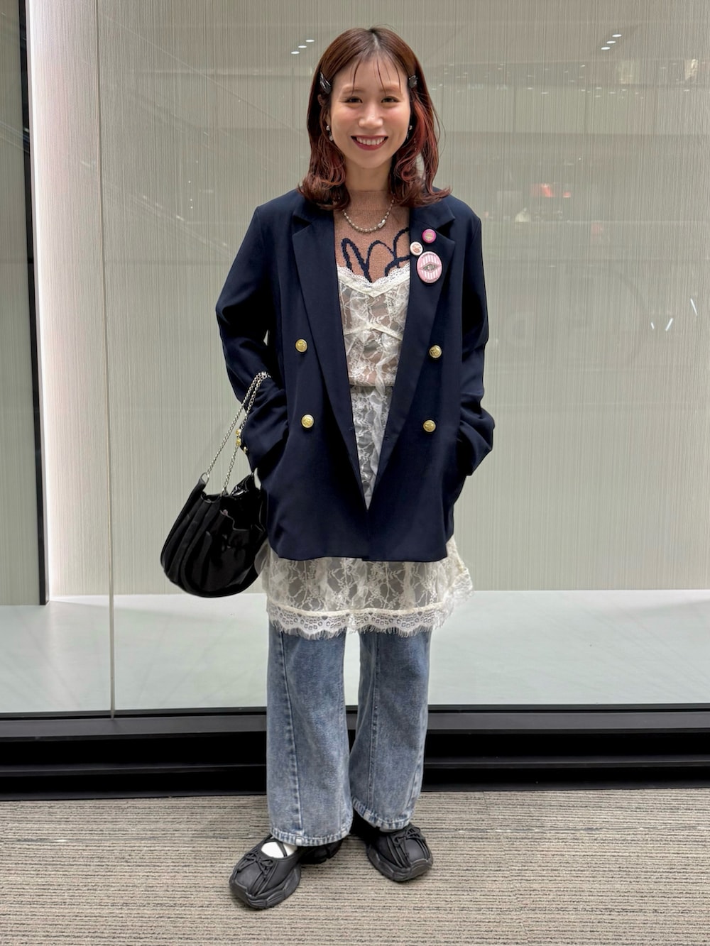 ブルー系のテーラードジャケット、ホワイト系のキャミソール、ブルー系のデニムパンツを着用したレディースの冬コーディネートの2枚目の写真