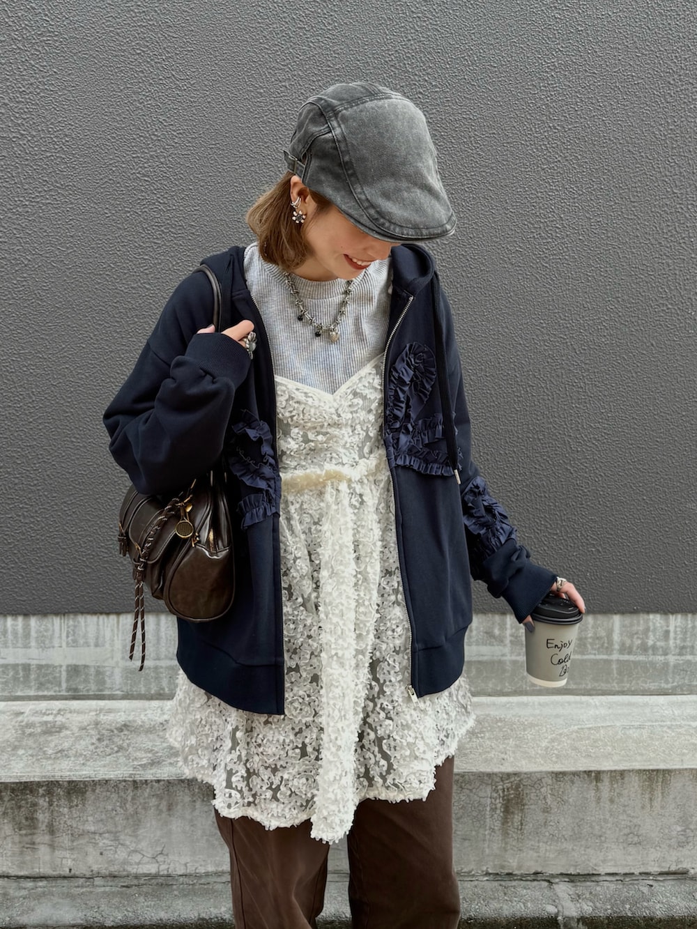 ホワイト系のチュニック、ブラウン系のスニーカー、ブルー系のパーカーを着用したレディースの秋コーディネートの2枚目の写真